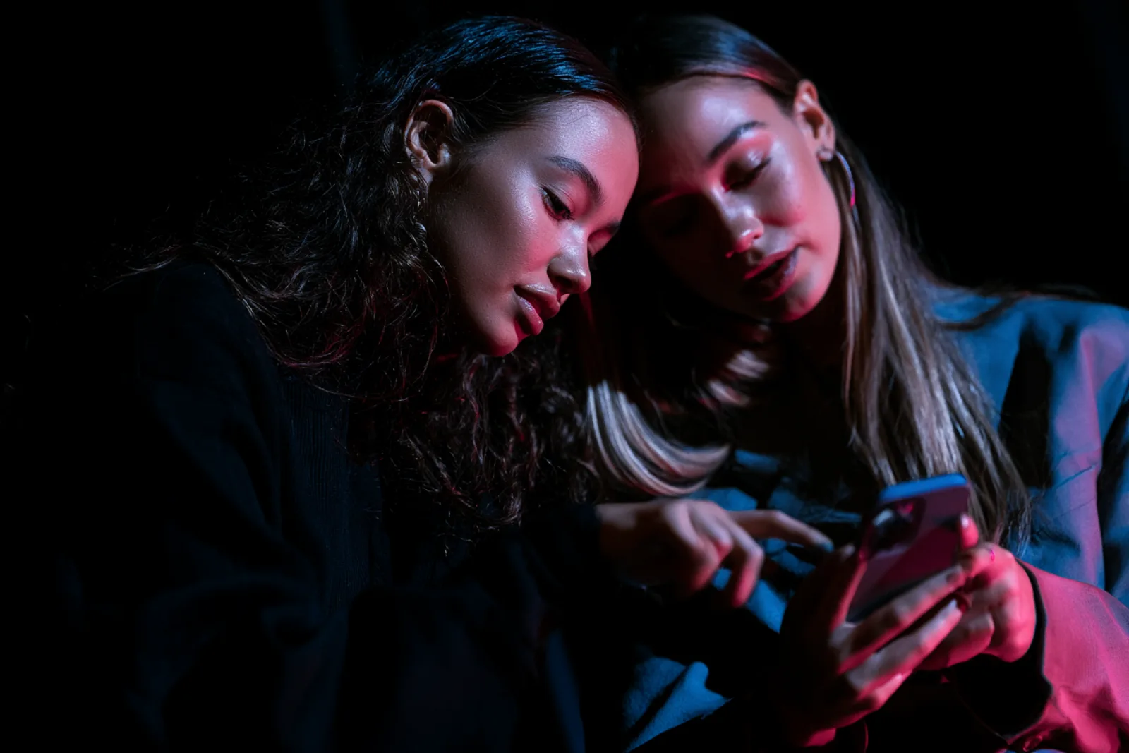 Creadoras de contenido revisando una campaña de influencer marketing en un celular